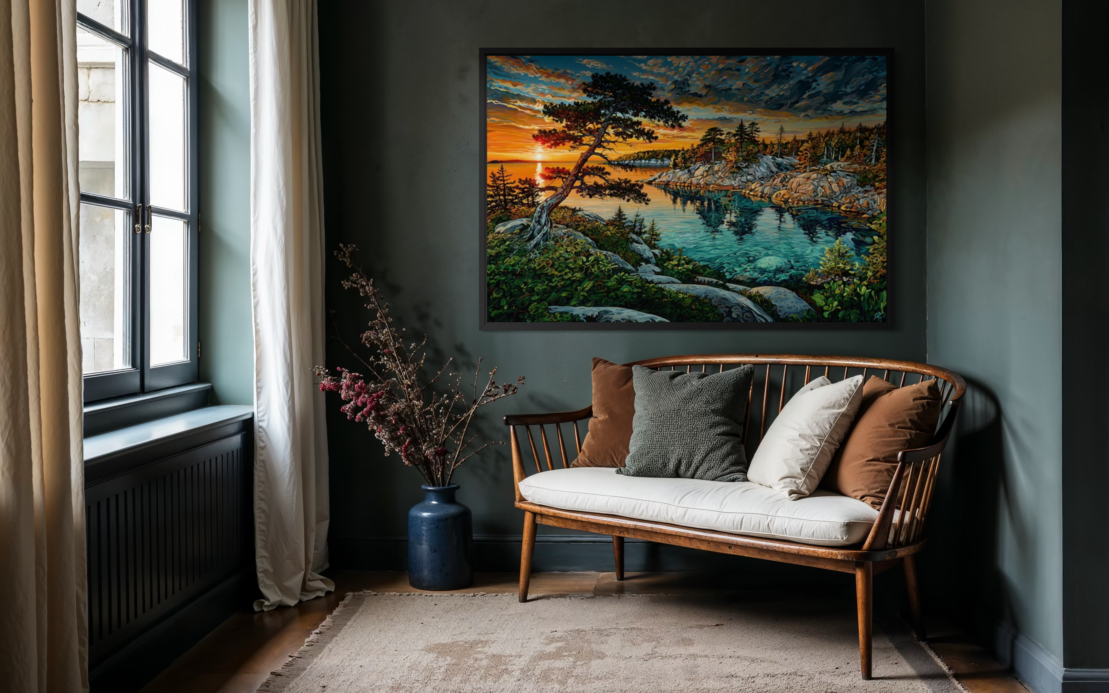 A large framed landscape art print depicting a scenic lake at sunset, hung on a dark gray wall above a wooden bench with neutral-colored cushions in a styled room setting.