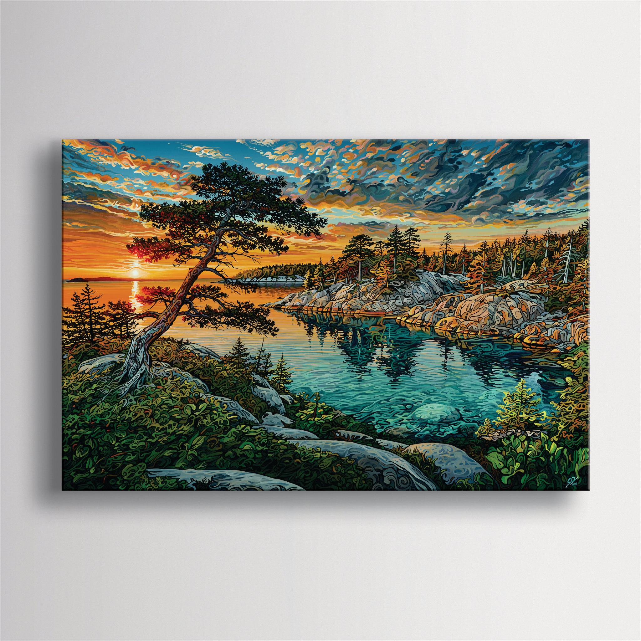 A square canvas wall art print depicting a vibrant coastal sunset scene with a lone pine tree, rocky shoreline, turquoise water, and dramatic clouds, shown hanging on a light gray wall.