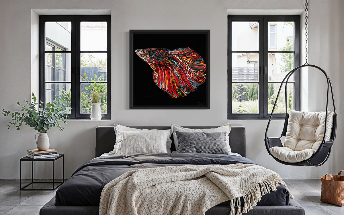 A framed wall art print by Jeff Dillon FIne Art of a colorful betta fish on a black background, displayed above a bed in a modern, stylishly decorated bedroom with a hanging chair, windows, and plants.