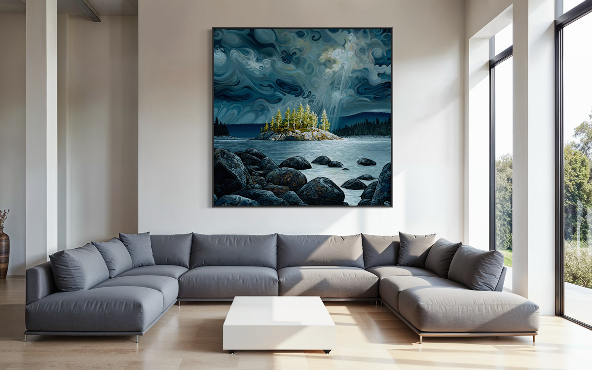 A large square canvas print of a moody blue and gray lake landscape with an island and dark rocks, displayed on a light wall above a modern gray sectional sofa in a bright, contemporary living room.