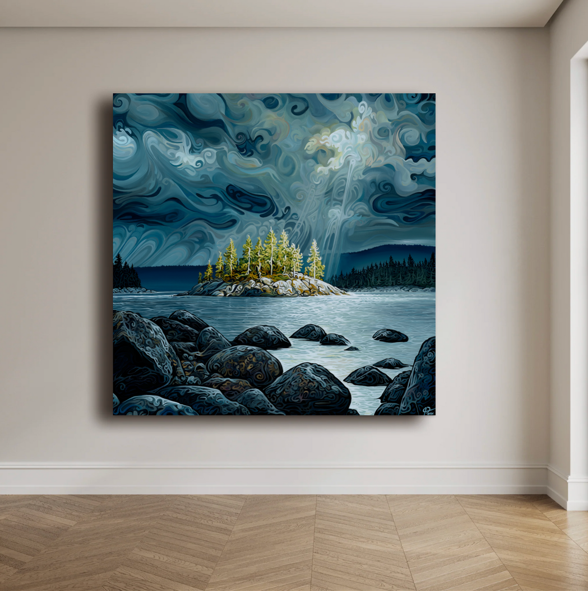 A square canvas wall art print depicting a moody blue and gray lakeside landscape with an island of yellow-green trees, hung on a beige wall above a wood floor.
