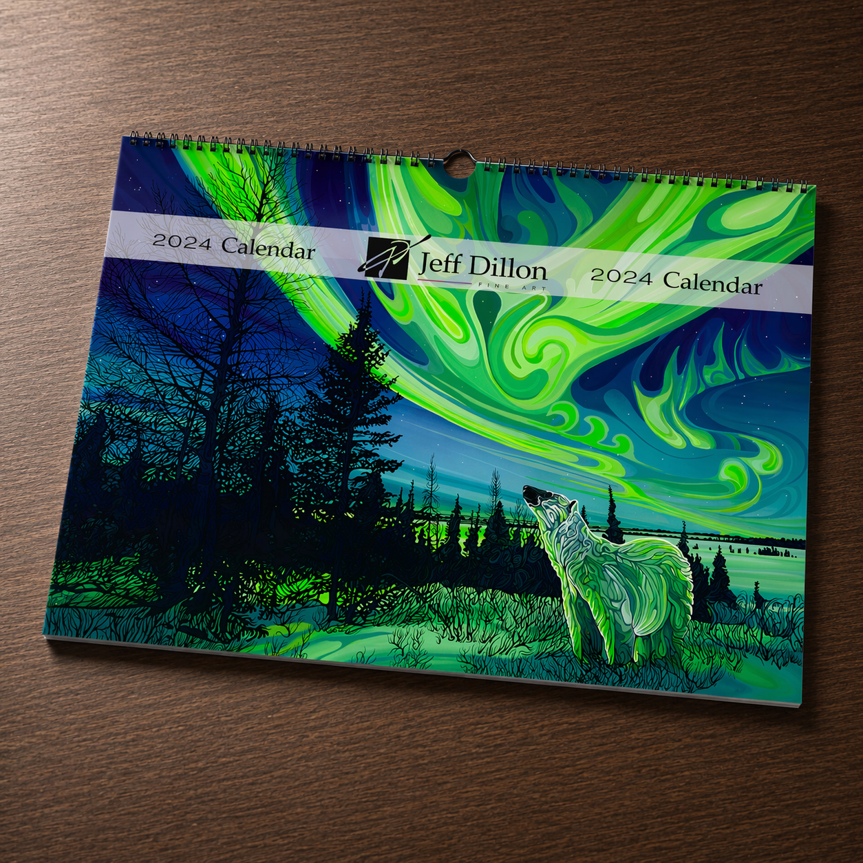 A wolf beneath vibrant northern lights, artwork by Jeff Dillon Fine Art, featured on a wall calendar.